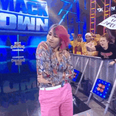 a woman in pink pants is standing in front of a sign that says mack down