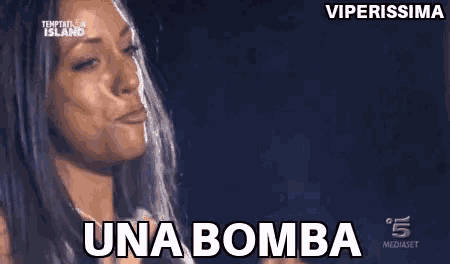 a woman is standing in front of a black background and says una bomba