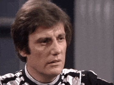 a close up of a man 's face with a striped shirt