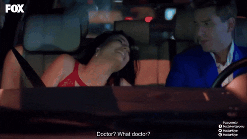 a man and a woman are sitting in a car with the fox logo on the bottom right