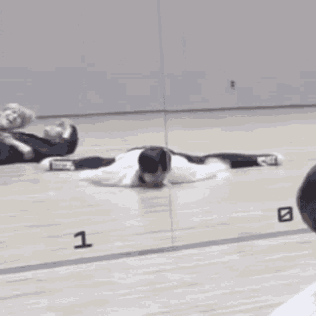 a person is laying on the floor doing a split .