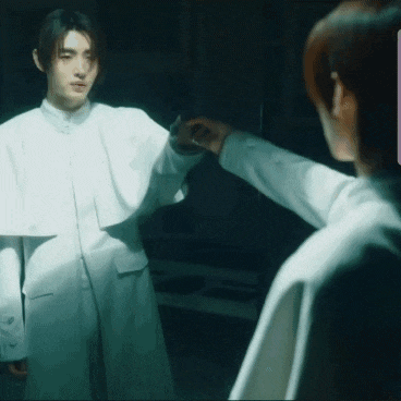 a man in a white robe is reaching out to another man