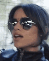a close up of a woman wearing sunglasses and headphones