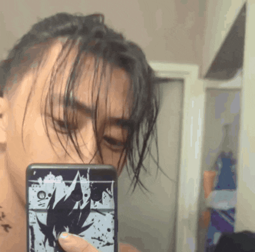 a man is taking a picture of himself in the mirror with a phone case that says ' goku ' on it