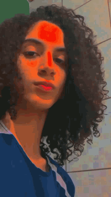 a girl with curly hair is sticking out her tongue