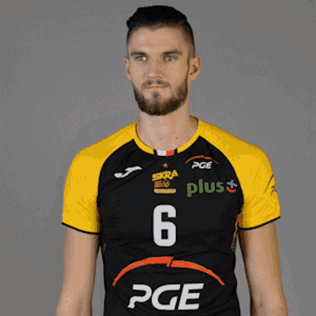 a man is wearing a black and yellow pge jersey