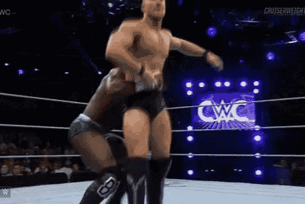 two men are wrestling in a wrestling ring with a referee watching .