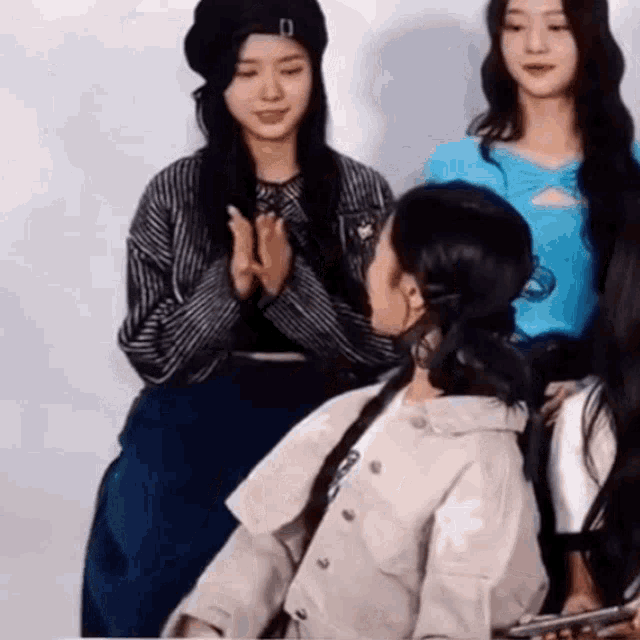 a group of girls are standing next to each other and clapping their hands .