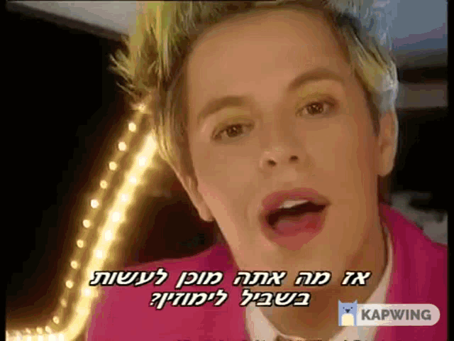 a man in a pink jacket is singing in a video with a caption that says kapwing