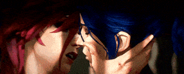 a couple of cartoon characters are kissing each other . one of the characters has red hair and the other has blue hair .