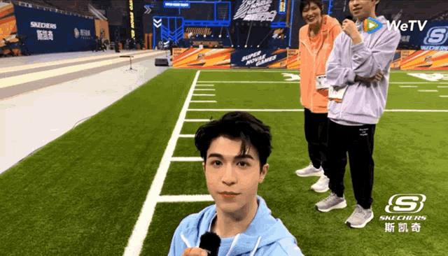 a man taking a selfie on a field with skechers written on the side