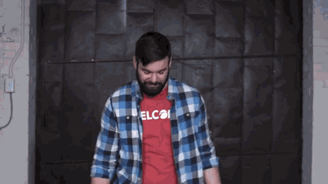 a man wearing a red elcoi shirt is dancing