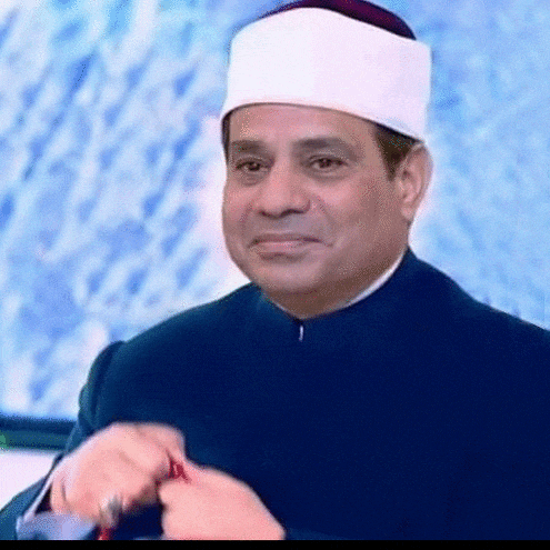 a man wearing a white turban and a black jacket is holding a ring .