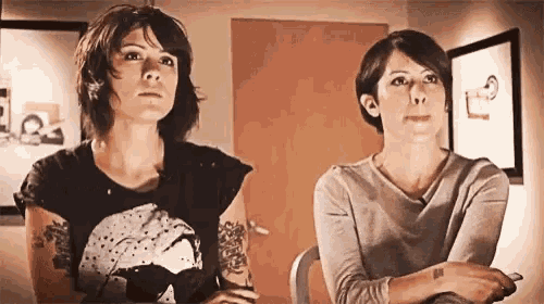 two women are sitting next to each other in a room looking up .