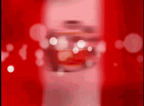 a blurred image of a coca cola bottle on a red background .