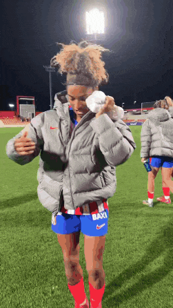 a female soccer player with the word baxi on her shorts is standing on the field