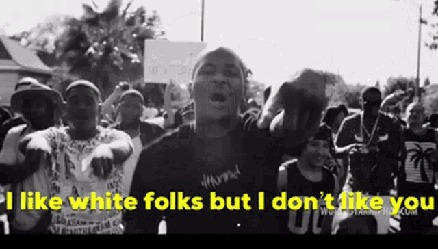 a man stands in front of a crowd with the words i like white folks but i don 't like you