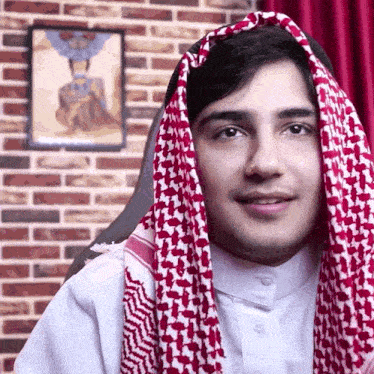 a man wearing a red white and black scarf around his head