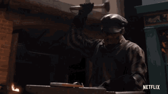 a man is hammering a piece of metal on an anvil with netflix written on the bottom