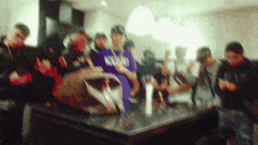 a group of people are gathered around a table and one of them is wearing a purple shirt that says kyland