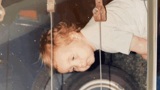 a baby is laying on its back in front of a window