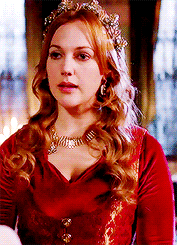 a woman in a red dress with a tiara on her head .