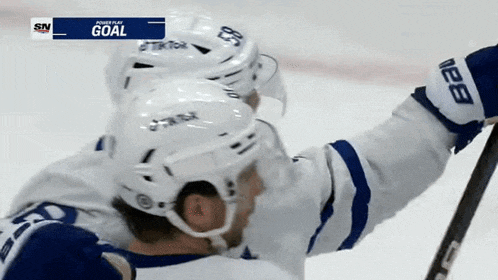 a hockey player is celebrating a goal with his teammate