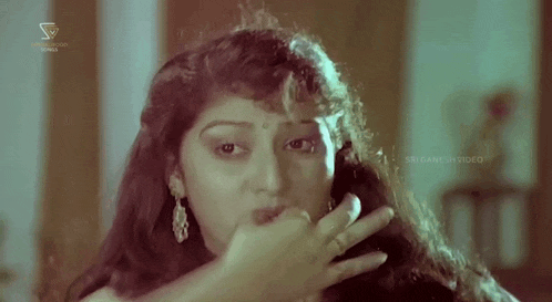 a close up of a woman 's face with a ring on her finger .