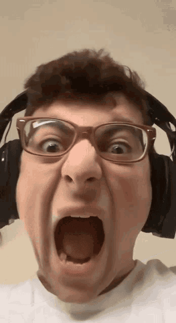 a man wearing glasses and headphones is making a face