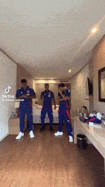 a group of men are dancing in a hotel room with tik tok written on the bottom