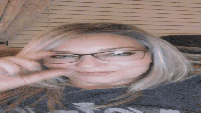 a woman wearing glasses is giving a thumbs up sign