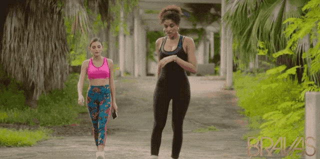 two women are walking down a path with bravas written on the side