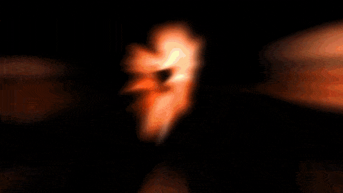 a blurred image of a flower with orange petals on a black background