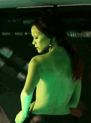 a naked woman with green paint on her face
