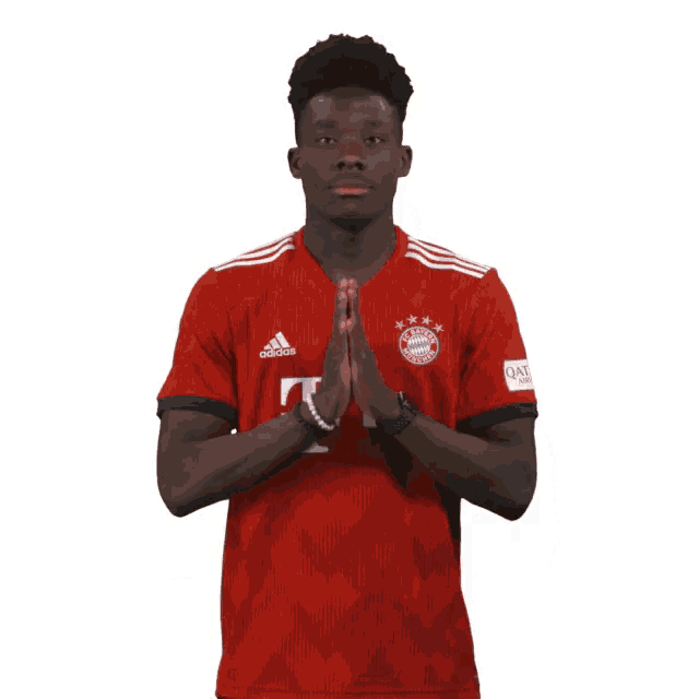a man wearing a red adidas shirt with the word qatar on the sleeve