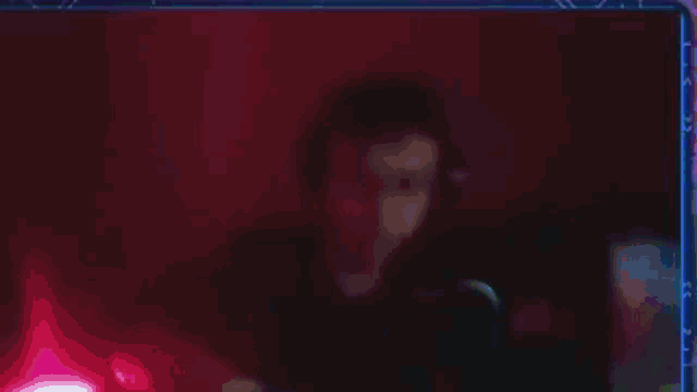 a blurry picture of a person in a dark room with green lights .
