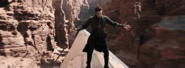 a man in a black coat is standing on top of a plane