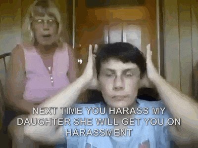 a man is covering his ears with his hands while a woman screams in the background .