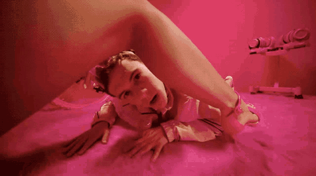 a woman laying on the floor with a pink background and a sign that says ' a ' on it