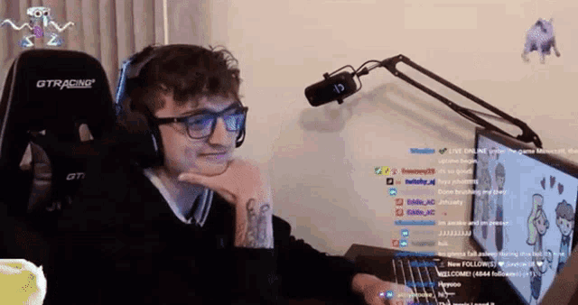 a man wearing headphones and glasses sits in front of a gtracing gaming chair