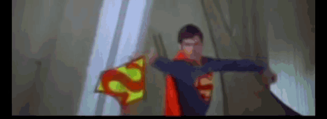 a blurry picture of a man in a superman costume holding a flag with the letter s on it .