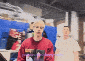 a man wearing a red sweater with a picture of a man on it is standing next to another man