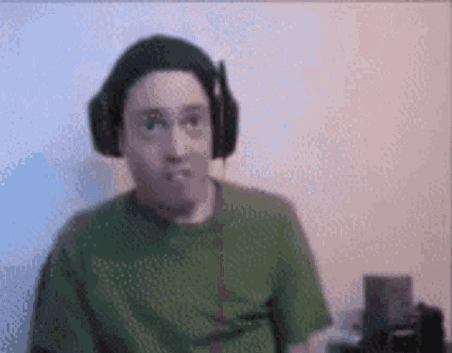 a man is wearing headphones and a green shirt