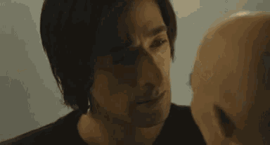 a close up of a man 's face with a bald man 's head in the background .