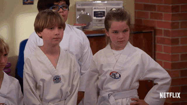 a group of kids wearing white karate uniforms with a netflix logo in the corner