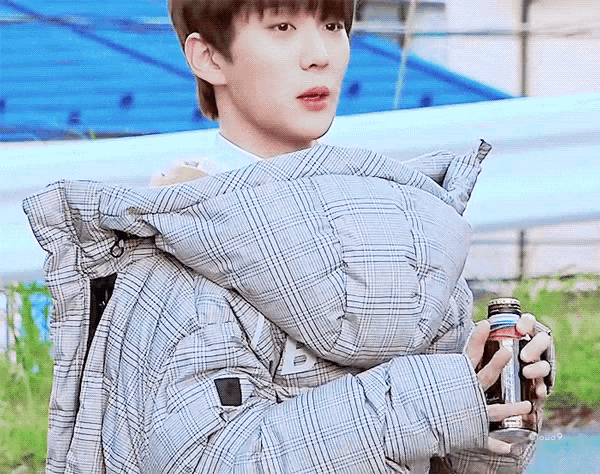a man wearing a plaid jacket with the letter b on the hood
