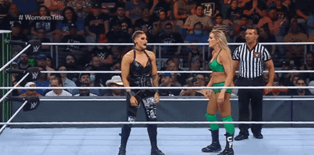 two women are standing in a wrestling ring talking to each other