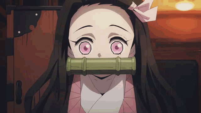 a close up of a girl with a bamboo tube in her mouth