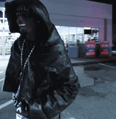 a man wearing a hooded jacket with the word miu on the back of it