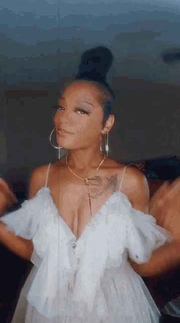 a woman in a white dress has a tattoo on her chest